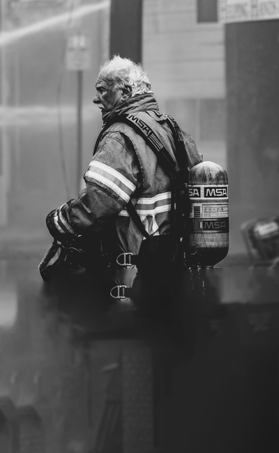 An older gentleman with white hair in firefighter uniform