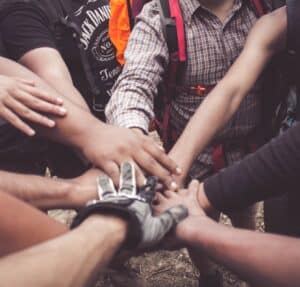 A group of people with their hands together as a team cheer