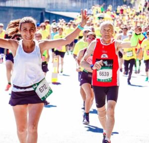 A marathon with a woman giving the peace sign and a man giving a thumbs up
